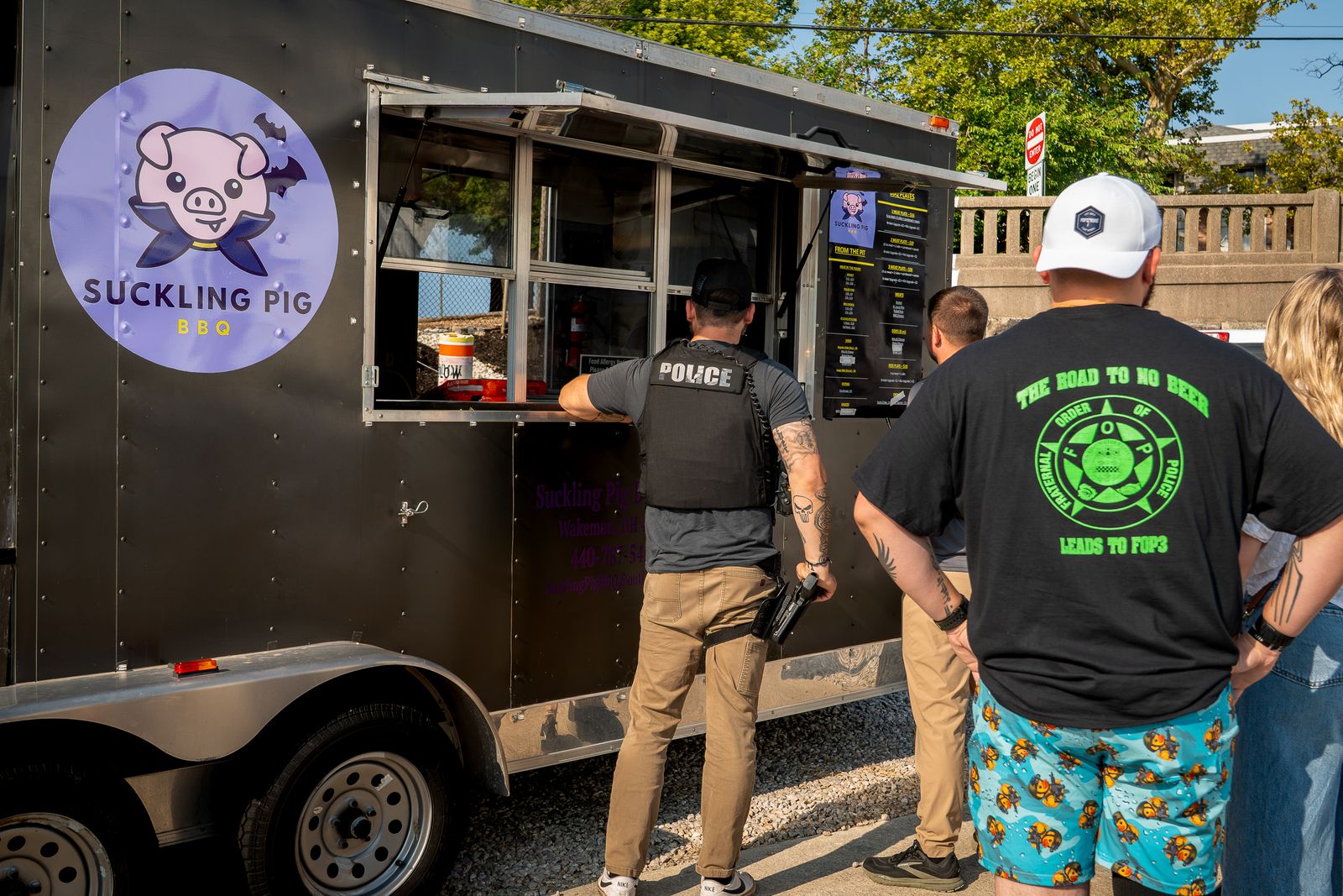 Customers lined up ordering at the Suckling Pig BBQ food truck window